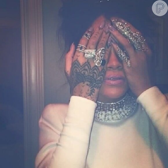 Rihanna exibe seus inúmeros anéis diantes de suas tatuagens