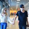 Louise D'Tuani e Eduardo Sterblitch caminham de mãos dadas pelo aeroporto Santos Dumont