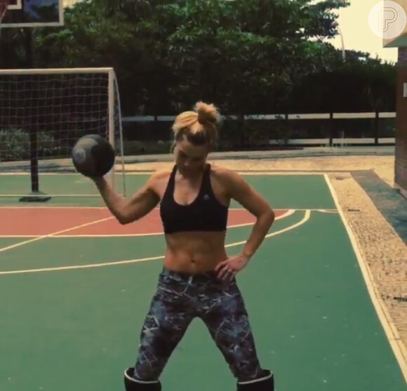 Carolina Dieckmann alterna exercícios com uma bola pesada