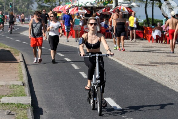 Bianca Bin pedala com a barriga de fora na orla da Barra da Tijuca, na Zona Oeste do Rio de Janeiro