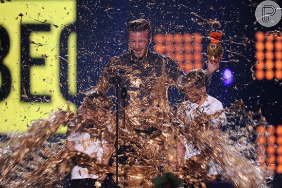 Tinta dourada cai em cima de David Beckham e dos filhos