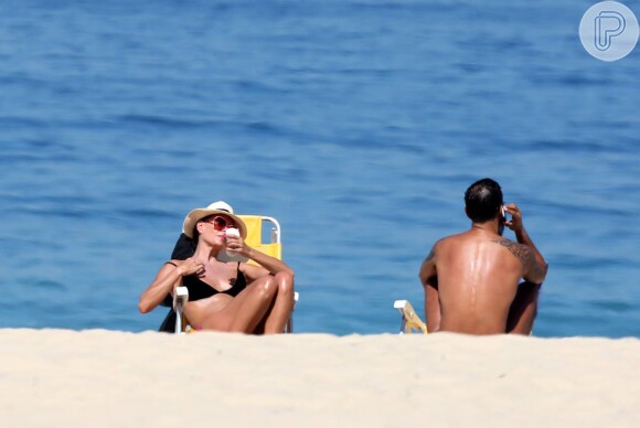 Carolina Ferraz curtiu a segunda-feira, 11 de agosto de 2014, na praia do Leblon, na Zona Sul do Rio. De biquíni e ao lado do namorado, o médico Marcelo Martins, a atriz mostrou que está em ótima forma física aos 46 anos