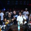 Caio Castro posa sorridente com os músicos do grupo Pur'amizade