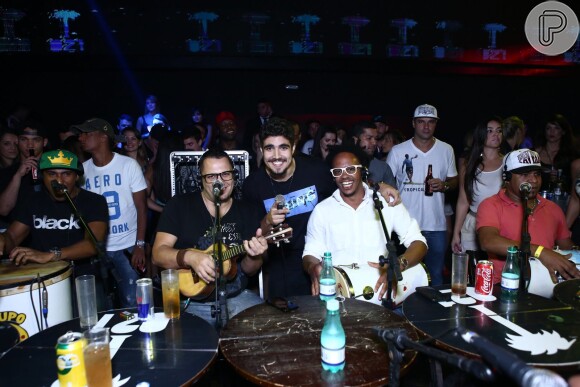 Caio Castro posa sorridente com os músicos do grupo Pur'amizade