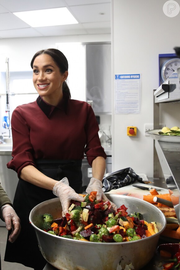 Meghan Markle cozinha ao lado de voluntárias da Cozinha Comunitária Hubb, em Londres, em 21 de novembro de 2018