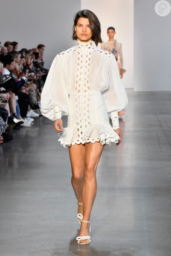 Branco total é a cara do verão! O vestido curtinho Zimmermann tem elemtnos em alta: gola alta e mangas bufantes