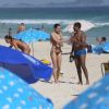 Sasha Meneghel devolve o celular para o fã após fazer uma foto com ele na praia
