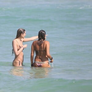 Sasha Meneghel conversa com amiga dentro do mar em dia de praia