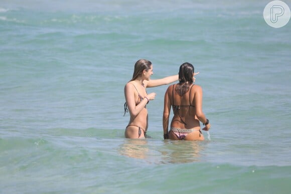 Sasha Meneghel conversa com amiga dentro do mar em dia de praia
