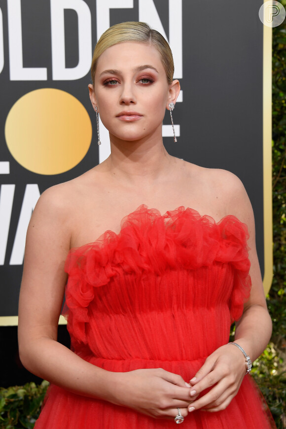 Atriz da série 'Riverdale', Lili Reinhart apostou na sombra laranja para combinar com o vestido coral no Globo de Ouro 2019
