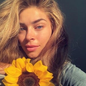 Grazi Massafera exibiu sua beleza natural em uma selfie com um girassol