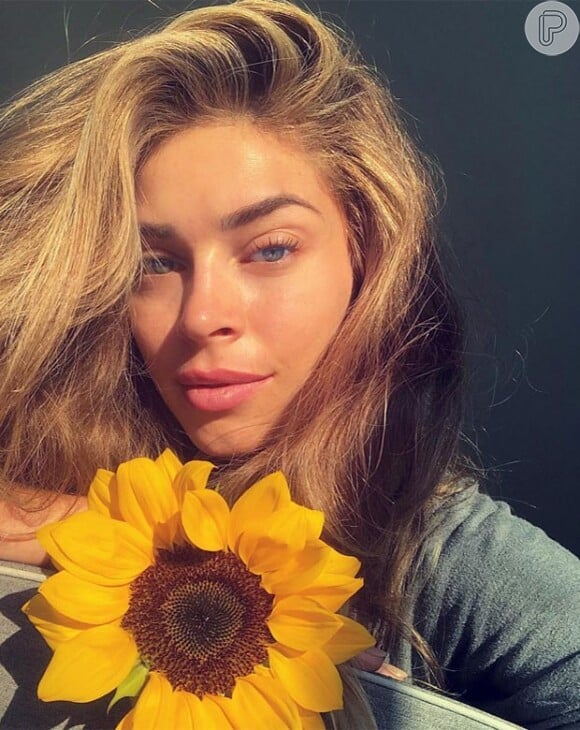 Grazi Massafera exibiu sua beleza natural em uma selfie com um girassol