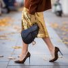 Dicas pra usar dourado no look: saia dourada acendendo o visual junto à Saddle Bag da Dior e scarpin em animal print