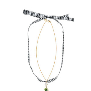 O choker, com pingente de abacaxi e fita xadrez, custa o equivalente a R$1,3 mil