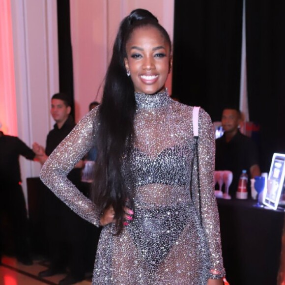 Iza combinou brilho e transparência em um vestido de gola alta e colocou por cima de um conjunto de lingerie preta. A cantora apostou ainda na tendência da bota-meia