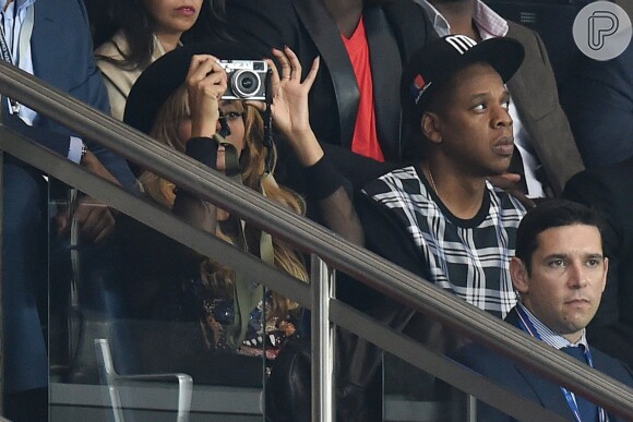 Beyoncé faz alguns registros do jogo com uma câmera vintage ao lado de Jay-Z 
