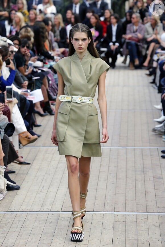 Colete usado como vestido, cinto para marcar a cintura e definir a silhueta na trend do militarismo