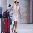 Mariana Ximenes elege vestido branco e sandália com ponto de cor amarela em aeroporto no Rio