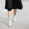Saia midi preta com bota branca garante um contraste fashion no look de outono/inverno 2019