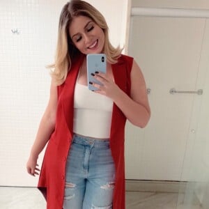 Marilia Mendonça combinou uma calça jeans destroyed com um cropped branco que valorizou o shape da artista