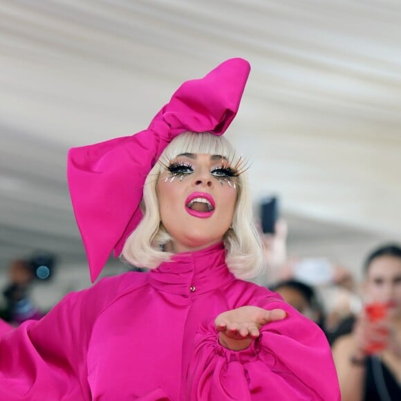 Lady Gaga chegou com um vestido pink dramático com uma cauda longa e aessório na cabeça da mesma cor do look