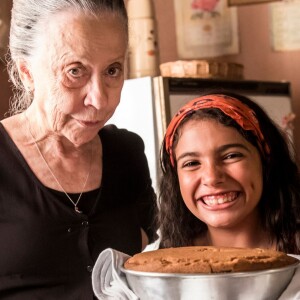 Maria da Paz (Juliana Paes), ainda criança, vai aprender com a avó, Dulce (Fernanda Montenegro) a fazer bolos, na novela 'A Dona do Pedaço'.