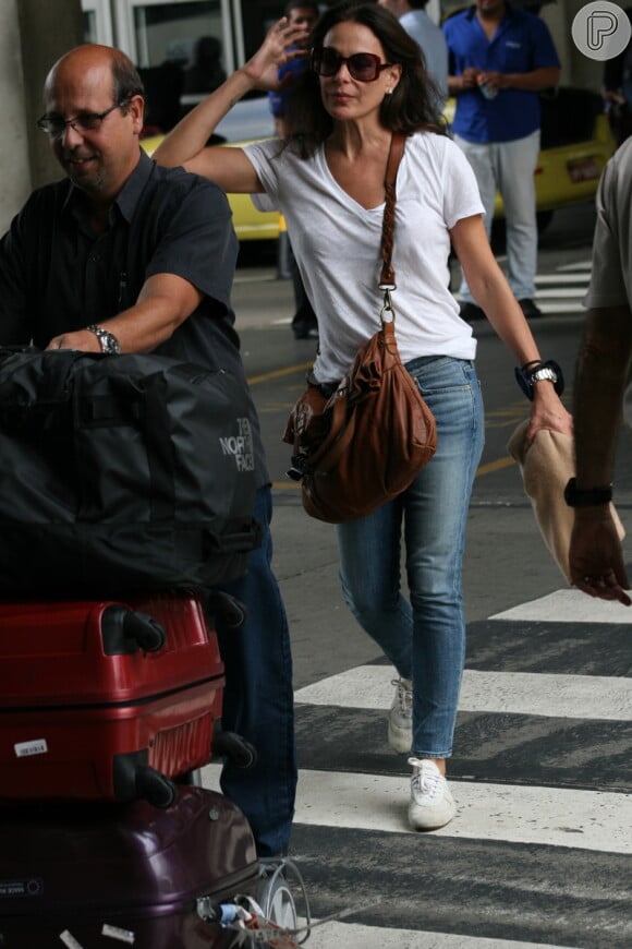A atriz saiu do aeroporto com a ajuda de um maleiro