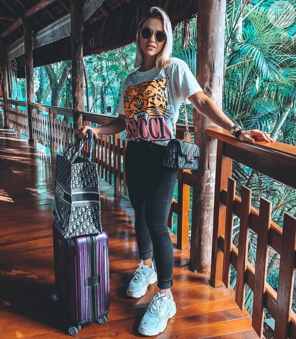 Andressa Suita combinou calça jeans e blusa inspirada na logomania para viajar com muito estilo.