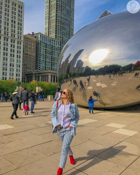Luisa Sonza aproveitou viagem para Chicago com jaqueta jeans, calça listrada e detalhes em vermelho no look.