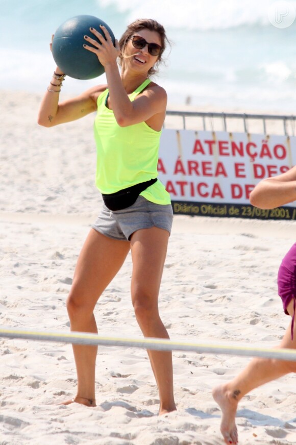 Grazi Massafera usa uma bola para se exercitar na praia