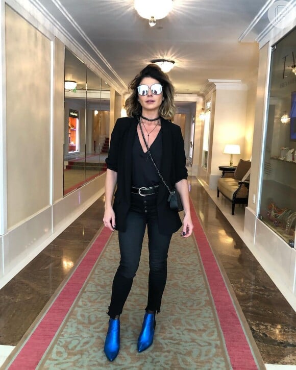 Giovanna Antonelli quebra look total black com bota melizada azul