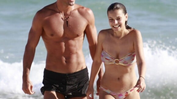 Milena Toscano rola em areia de praia no Rio com ator Jeremy Jonathan Zendwick