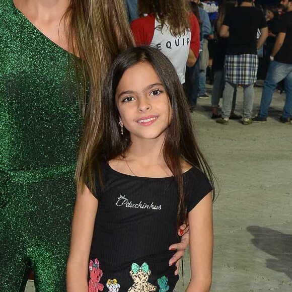 Filha gêmea de Luciano Camargo comina bota de cano alto com saia quadriculada para show