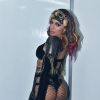 Anitta combinou um look preto com detalhes holográficos a uma meia arrastão