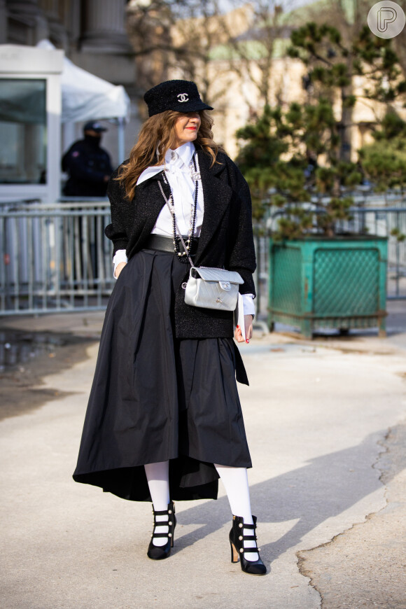 A saia godê mídi preta com a meia-calça branca combina superbem no look preto e branco
