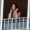 Jennifer Lawrence aparece sem maquiagem e falando no celular em varanda de hotel