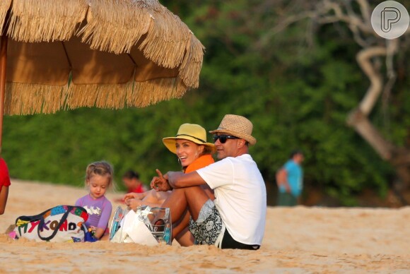 De roupa lilás de neoprene (típica dos surfistas), a menina brincou com a areia enquanto a mãe conversava com amigo