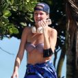 A apresentadora Ellen Jabour aposta em visual descolado ao praticar caminhda na praia: biquíni, short, boné e mais