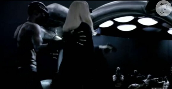 Lady Gaga atira em homens mascarados e sem camisa através de um espelho