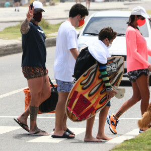 Marcos Mion acena para fotógrafo ao sair da praia