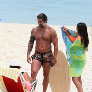 Marcos Mion conversa com a mulher, Suzanna Gullo, sentada em cadeira de praia