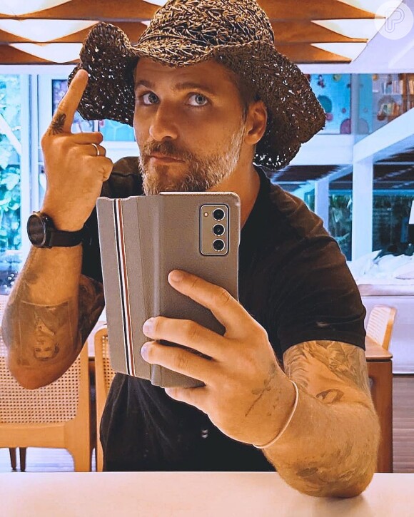 Bruno Gagliasso combina camiseta preta e chapéu de praia para visitar rancho