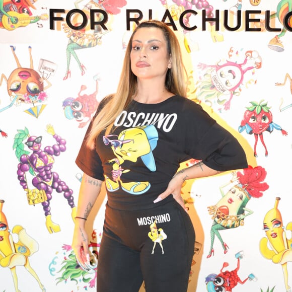 Cleo usou look comfy preto da grife Moschino para a Riachuelo, com estampas da nova coleção, de frutas e personagens da Warner Bros