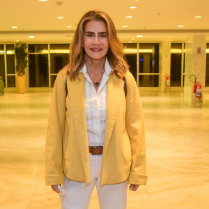 Maitê Proença completou o look com casaco amarelo queimado