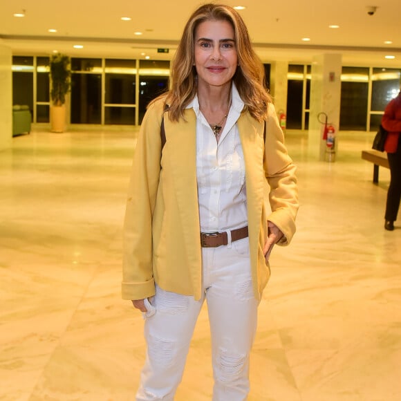 Maitê Proença apostou em camisa e calça brancas, com cinto e bota marrons, para ir ao teatro