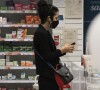 Em raro flagra, Marisa Monte caminhou pela farmácia com fones de ouvido