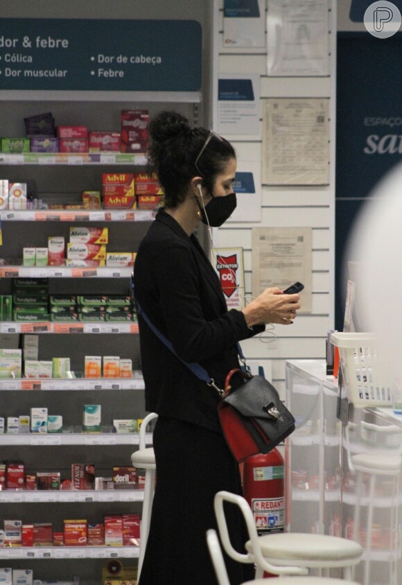 Em raro flagra, Marisa Monte caminhou pela farmácia com fones de ouvido