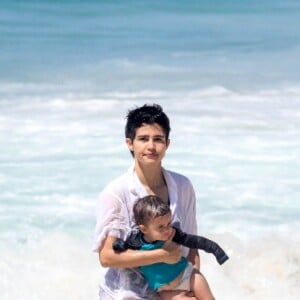 Nanda Costa e Lan Lanh carregaram as filhas gêmeas no colo em dia de praia