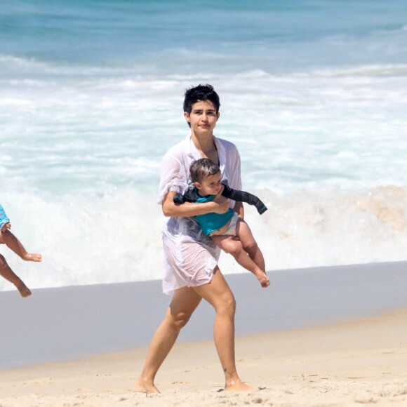 Nanda Costa e Lan Lanh carregaram as filhas gêmeas no colo em dia de praia