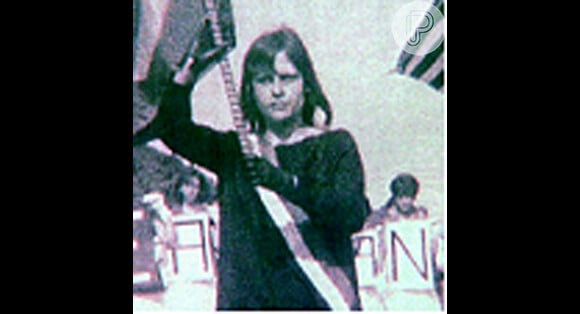 Em foto da infância, ela segura a bandeira do Brasil na escola